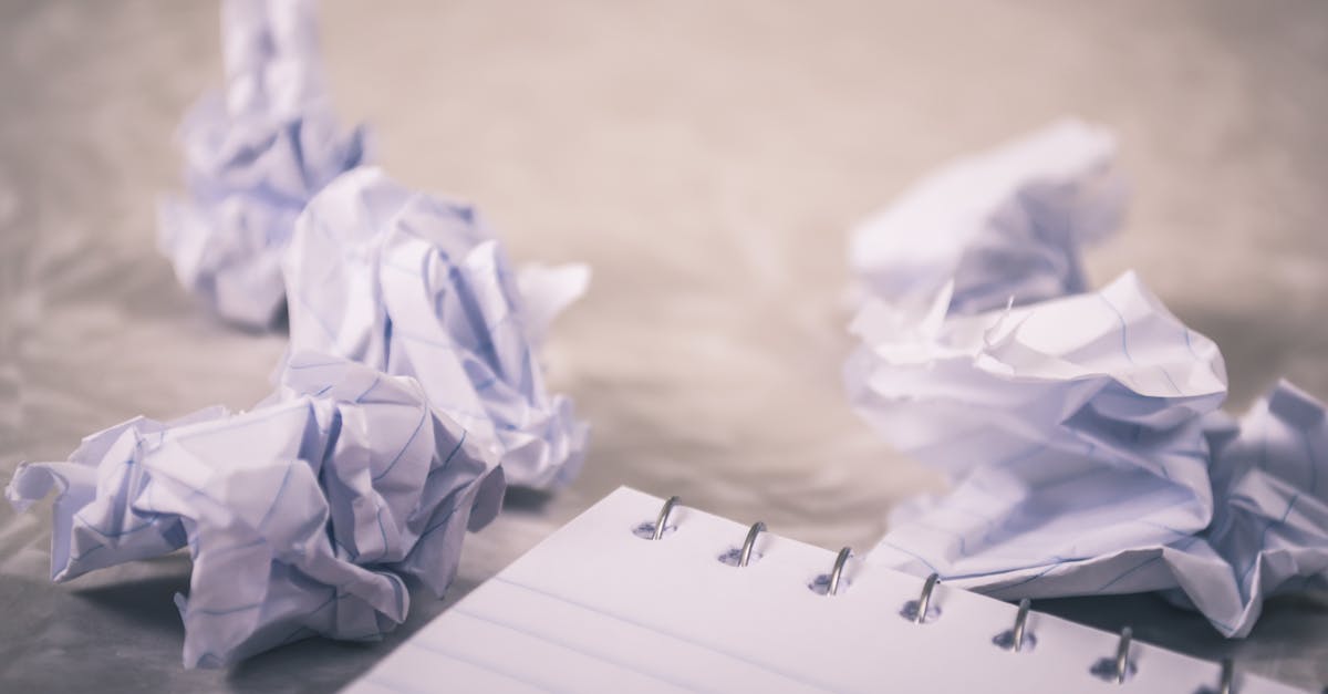 Crumpled-papers-scattered-around-a-notepad-symbolizing-creative-process-and-ideas